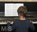 20.02.2018, Kinder und Familie, (Modelreleased). Grundschler spielt Zuhause im Wohnzimmer am Klavier.