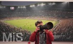 10.4.2018, Fussball Championsleague 2017/2018,  FC Bayern Mnchen Pressekonferenz in der Allianz-Arena vor dem Championsleague-Spiel gegen Sevilla. Ein Fotograf mit Teleobjektiv vor einem Bild der Allianz-Arena.
