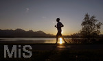 16.10.2018, Hopfensee in Bayern, Der Hopfensee bei Fssen im Allgu im Sonnenuntergang, ein Jogger luft auf der Promenade am See.