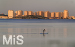 15.01.2020,  La Manga, Spanien. Playa Mar de Cristal, der Binnensee Mar Menor (Kleines Meer) in der Region Murcia. SUP-Sportler paddelt bers Wasser. Hinten die Hotels und Wohnkomplexe der Stadt La Manga del Mar Menor.