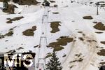 25.03.2024 , Ein Skilift in Grasgehren im Allgu, Trostlos fr Wintersportler und Liftbetreiber, wenig Schneefall, Gras und Erde schaut aus der dnnen Schneeschicht hervor.  