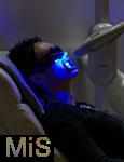 12.04.2024, FIBO-Messe fr Fitness, Wellness und Gesundheit in Kln. Ein Besucher lsst seine Zhne mittels blauem Licht bleichen.