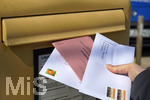 26.03.2020,  Gemeinderatswahl, Brgermeister-Wahl in Bayern 2020, Wahlbezirk Bad Wrishofen in Bayern. Es ist eine Stichwahl ntig, hier whlt eine Brgerin per Briefwahl und wirft den Umschlag mit Schutzhandschuhen in einen Briefkasten, zusammen mit einem Brief fr die Agentur fr Arbeit.
