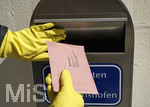 26.03.2020,  Gemeinderatswahl, Brgermeister-Wahl in Bayern 2020, Wahlbezirk Bad Wrishofen in Bayern. Es ist eine Stichwahl ntig, hier whlt eine Brgerin per Briefwahl und wirft den Umschlag mit Gummihandschuhen in einen Briefkasten am Rathaus Bad Wrishofen.