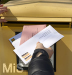 26.03.2020,  Gemeinderatswahl, Brgermeister-Wahl in Bayern 2020, Wahlbezirk Bad Wrishofen in Bayern. Es ist eine Stichwahl ntig, hier whlt eine Brgerin per Briefwahl und wirft den Umschlag mit Schutzhandschuhen in einen Briefkasten, zusammen mit einem Brief fr die Agentur fr Arbeit.