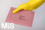 26.03.2020,  Gemeinderatswahl, Brgermeister-Wahl in Bayern 2020, Wahlbezirk Bad Wrishofen in Bayern in Zeiten der Corona-Pandemie. Es ist eine Stichwahl ntig, hier whlt eine Brgerin per Briefwahl und hlt den Umschlag mit Gummihandschuhen in der Hand.