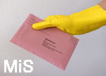 26.03.2020,  Gemeinderatswahl, Brgermeister-Wahl in Bayern 2020, Wahlbezirk Bad Wrishofen in Bayern in Zeiten der Corona-Pandemie. Es ist eine Stichwahl ntig, hier whlt eine Brgerin per Briefwahl und hlt den Umschlag mit Gummihandschuhen in der Hand.
