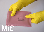 26.03.2020,  Gemeinderatswahl, Brgermeister-Wahl in Bayern 2020, Wahlbezirk Bad Wrishofen in Bayern in Zeiten der Corona-Pandemie. Es ist eine Stichwahl ntig, hier whlt eine Brgerin per Briefwahl und hlt den Umschlag mit Gummihandschuhen in der Hand.