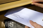 26.03.2020,  Eine Angestellte beantragt aufgrund der Corona-Krise schriftlich Kurzarbeit und wirft den Umschlag mit dem Antrag an die Agentur fr Arbeit in einen Briefkasten 