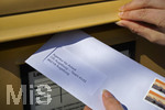 26.03.2020,  Eine Angestellte beantragt aufgrund der Corona-Krise schriftlich Kurzarbeit und wirft den Umschlag mit dem Antrag an die Agentur fr Arbeit in einen Briefkasten 