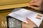 26.03.2020,  Eine Angestellte beantragt aufgrund der Corona-Krise schriftlich Kurzarbeit und wirft den Umschlag mit dem Antrag an die Agentur fr Arbeit in einen Briefkasten 