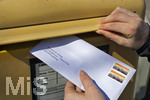 26.03.2020,  Eine Angestellte beantragt aufgrund der Corona-Krise schriftlich Kurzarbeit und wirft den Umschlag mit dem Antrag an die Agentur fr Arbeit in einen Briefkasten 