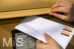 26.03.2020,  Eine Angestellte beantragt aufgrund der Corona-Krise schriftlich Kurzarbeit und wirft den Umschlag mit dem Antrag an die Agentur fr Arbeit in einen Briefkasten 