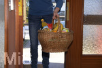 06.04.2020,  Symbolbild:  Frau bringt Lebensmittel in einem Einkaufskorb an die Haustre.  