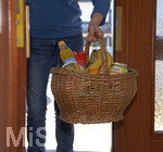 06.04.2020,  Symbolbild:  Frau bringt Lebensmittel in einem Einkaufskorb an die Haustre.  