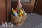 06.04.2020,  Symbolbild:  Frau in Quarantne holt ihre Lebensmittel in einem Einkaufskorb an der Haustre ab, die der Lieferservice dort abgestellt hat. 