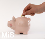 15.05.2020,  Sparschwein Symbolbild, Frau steckt ein Euro in ein Sparschwein.
