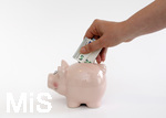 15.05.2020,  Sparschwein Symbolbild, Frau steckt 5 Euro-Schein in ein Sparschwein.