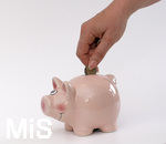 15.05.2020,  Sparschwein Symbolbild, Frau steckt Zwei Euro in ein Sparschwein.