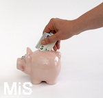 15.05.2020,  Sparschwein Symbolbild, Frau steckt 5 Euro-Schein in ein Sparschwein.