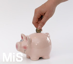 15.05.2020,  Sparschwein Symbolbild, Frau steckt Zwei Euro in ein Sparschwein.