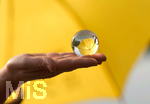16.06.2020, Mindelheim, Gelber Schirm mit einem Lensball auf einer Frauenhand. 