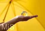 16.06.2020, Mindelheim, Gelber Schirm mit einem Lensball auf einer Frauenhand.
