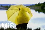 16.06.2020, Mindelheim, Abendlicht, Frau am Wasser hinter gelbem Regenschirm 