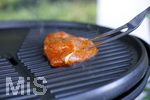 19.06.2020, Grillen auf dem Balkon im Sommer, Rohes Grillfleisch von der Pute, fertig mariniert kommt auf den Elektrogrill.