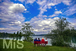 30.07.2020, Lechbruck am See im Allgu, Sommerurlaub in der Heimat. Feriengste geniessen den Ausblick von der Bank am Ufer auf den See.