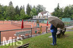 04.08.2020,  Kurpark in Bad Wrishofen im Regenwetter,  Tennisanlage ist leer,  Frau steht mit Regenschirm alleine am Rand der Anlage.