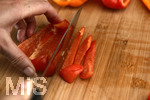 04.08.2020,  Paprika in der heimischen Kche bei der Zubereitung, Frau schneidet die Paprikaschote mit dem Messer in Streifen