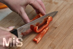 04.08.2020,  Paprika in der heimischen Kche bei der Zubereitung, Frau schneidet die Paprikaschote mit dem Messer in Streifen