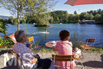 12.09.2020, Immenstadt im Allgu,  am Inselsee fahren die Wakeboarder am Schlepplift ber den See. Zwei Urlauber sitzen am Ufer im Cafe und beobachten die Sportler.