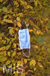 19.10.2020, Symbolbild, Corona-Krise, Eine Einweg-Maske hngt im Baum mit Herbstlaub.