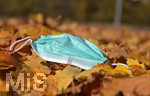 20.10.2020, Symbolbild, Corona-Krise, Eine Einweg-Maske liegt im Herbstlaub. 