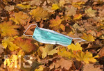 20.10.2020, Symbolbild, Corona-Krise, Eine Einweg-Maske liegt im Herbstlaub. 