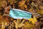 20.10.2020, Symbolbild, Corona-Krise, Eine Einweg-Maske liegt im Herbstlaub. 