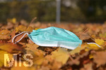 20.10.2020, Symbolbild, Corona-Krise, Eine Einweg-Maske liegt im Herbstlaub. 