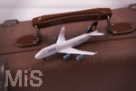 17.04.2021, Symbolbild, Lufthansa-Modelflugzeug auf einem Reisekoffer.     