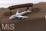 17.04.2021, Symbolbild, Lufthansa-Modelflugzeug auf einem Reisekoffer.     