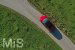 10.10.2021,  Ein roter Tesla Model 3 fährt auf einer Landstrasse bei Kempten im Allgäu.