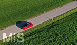 10.10.2021,  Ein roter Tesla Model 3 fährt auf einer Landstrasse bei Kempten im Allgäu.
