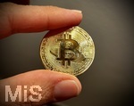 28.11.2021, Symbolbild, Bitcoin-Münze, Bitcoin-Goldmünze zwischen den Fingern.