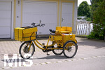 09.06.2022,  Ein Briefträger der Deutschen Post hat sein Transportrad vor einem Haus abgestellt um die Post an die Haustüre zu bringen.