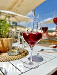 01.06.2022, Beliebtes Reiseziel der Deutschen, Mallorca.  Azur-Blaues Wasser in Cala Ratjada in einer kleinen Bucht. In einem Cafe wird der Fruchtige Wein Sangria in einem Glas serviert.