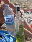 01.06.2022, Beliebtes Reiseziel der Deutschen, Mallorca. Auf der Baleareninsel tobt wieder das Touristische Leben, hier in Cala Ratjada ist der Strand Cala Agulla gut besucht. Landestypisches Getränk, der Likör HERBES und eine Wasserflasche stehen bereit.