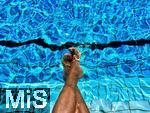 26.07.2022, Schwimmen im Freibad Bad Wörishofen (Bayern),  ein Mann sitzt am Schwimmbecken und lässt seine Beine ins Wasser baumeln.  (Model Release vorhanden)  