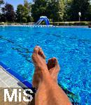26.07.2022, Schwimmen im Freibad Bad Wörishofen (Bayern),  ein Mann sitzt am Schwimmbecken am Wasser.  (Model Release vorhanden)  
