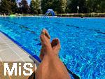 26.07.2022, Schwimmen im Freibad Bad Wörishofen (Bayern),  ein Mann sitzt am Schwimmbecken am Wasser.  (Model Release vorhanden)  